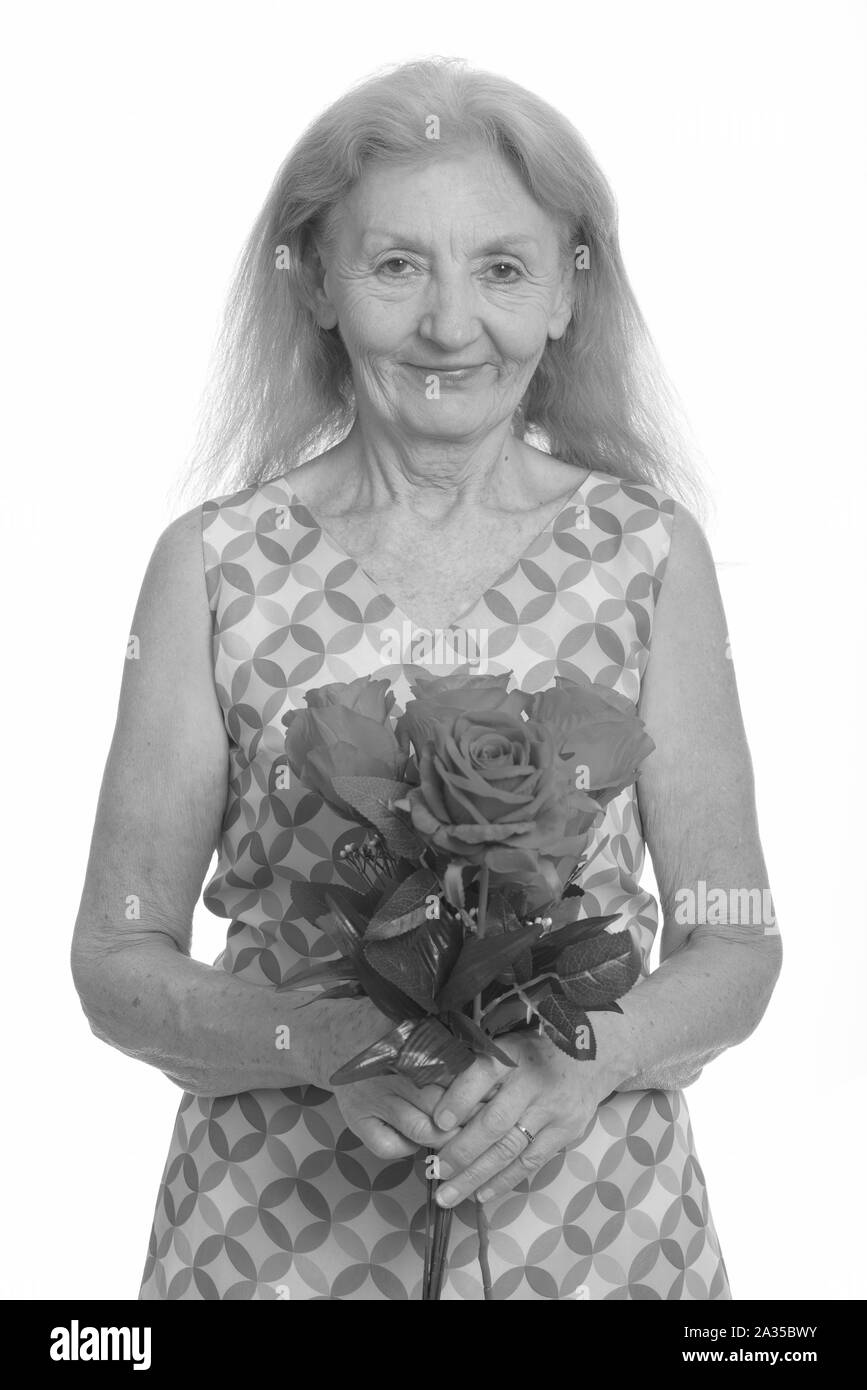 Studio shot der älteren Frau mit roten Rosen Stockfoto