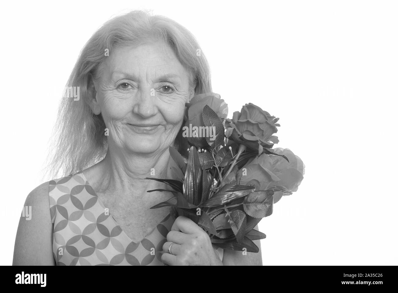 Studio shot der älteren Frau mit roten Rosen Stockfoto