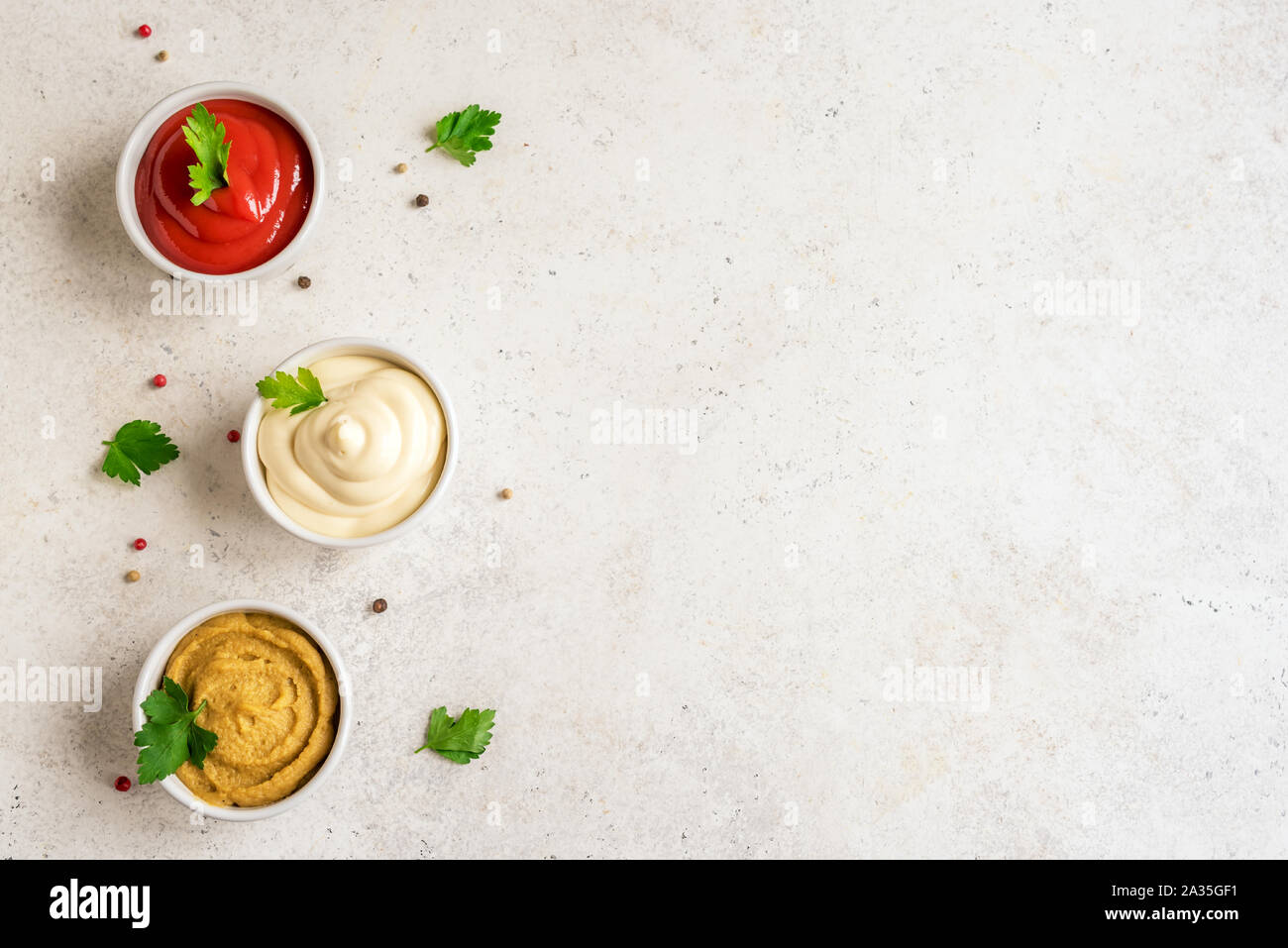 Drei klassische Saucen Ketchup, Mayonnaise und Senf auf weißem Hintergrund. Set der beliebten amerikanischen Saucen, Ansicht von oben, kopieren. Stockfoto