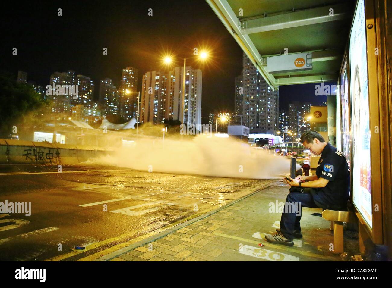 Hongkong, China. 4. Okt, 2019. Tausende von Demonstranten auf die Straßen von Hong Kong den Beschluss der Bundesregierung, die Notstandsgesetze zu berufen, zu Gesichtsmasken Verbot zu protestieren. Hier ein Zivilist ist hilflos Warten an der Bushaltestelle von Lung Cheung Straße, während der Bus unterbrochen wurde. Credit: Gonzales Foto/Alamy leben Nachrichten Stockfoto