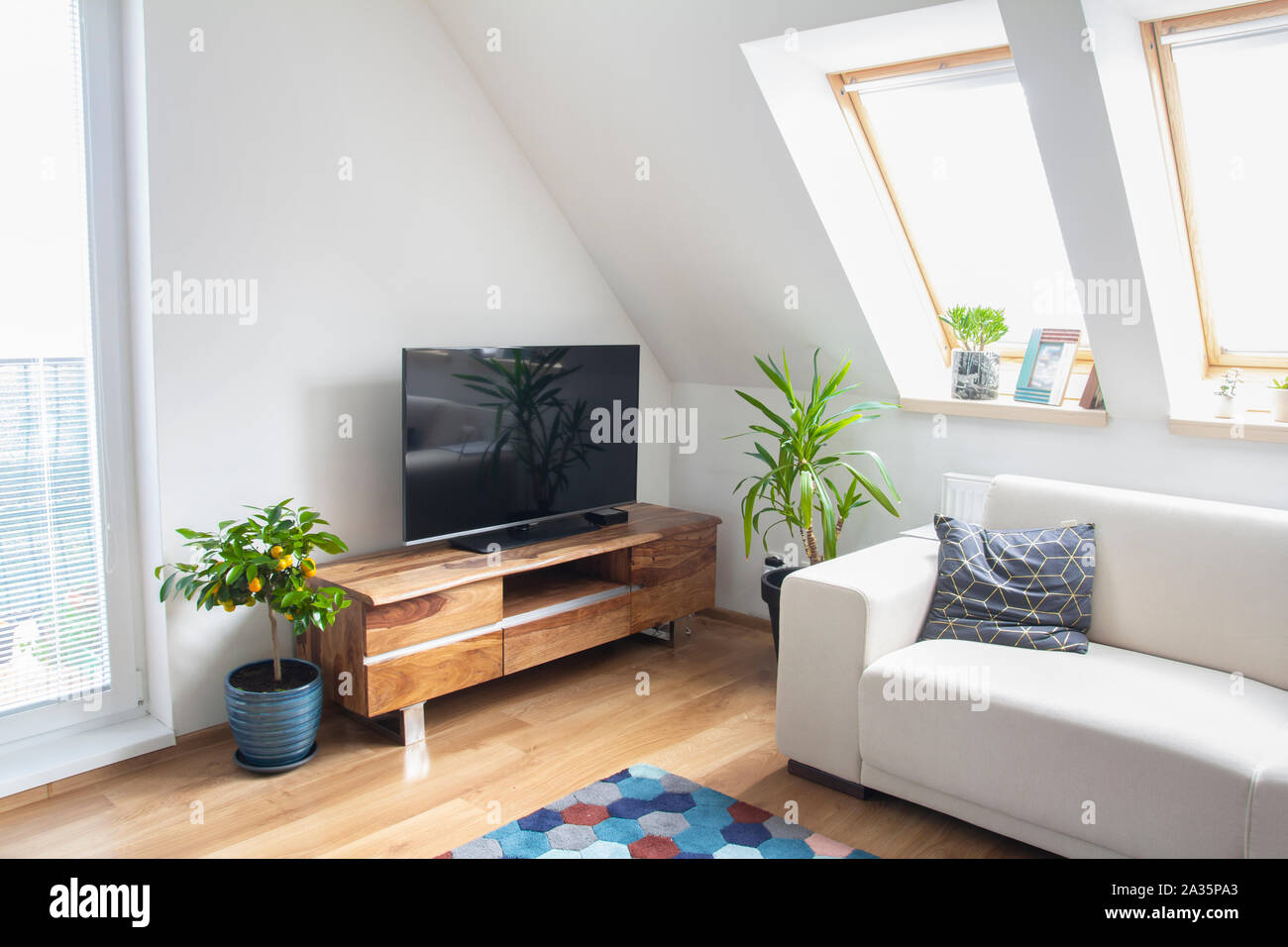 Zimmer mit TV-Ständer aus Holz und weißen Sofa Stockfoto