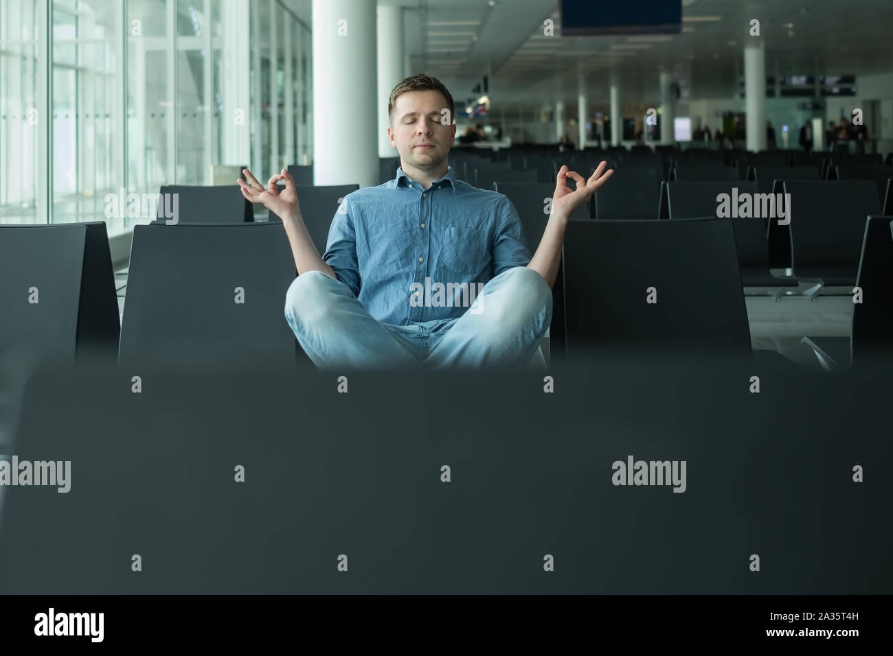 Reifer Mann im Flughafen meditieren vor dem Flug Stockfoto
