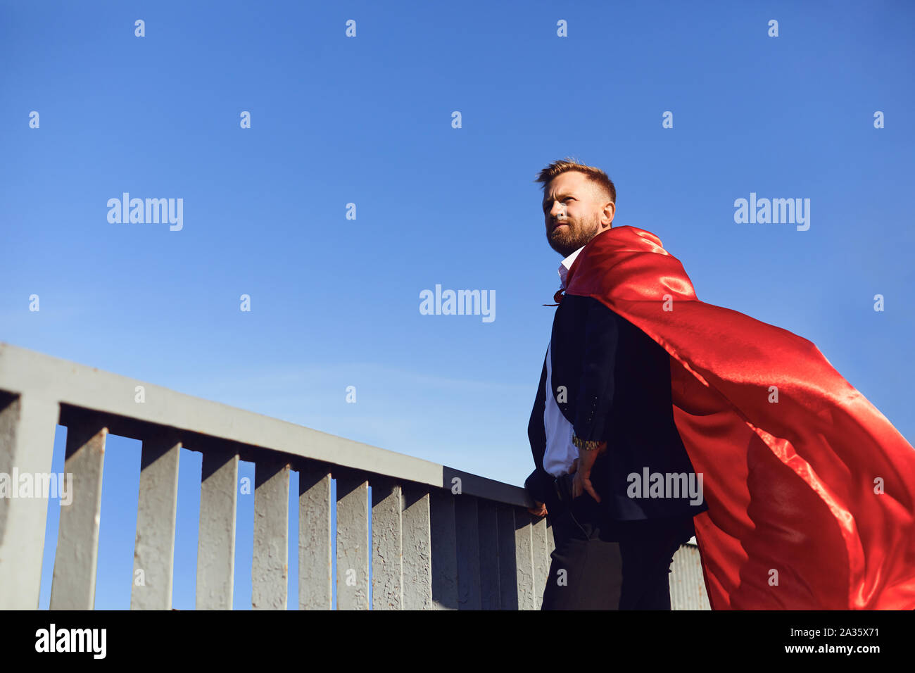 Erfolgreiche Superhelden Geschäftsmann auf dem Hintergrund des blauen Himmels Stockfoto