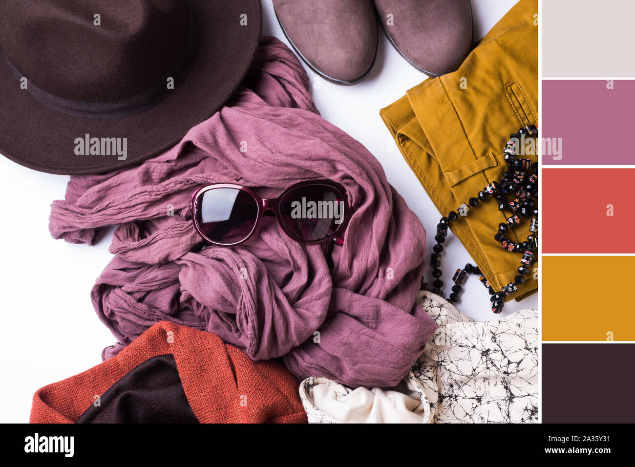 Flach mit der Kleidung der Dame, Hut, Sonnenbrille, Halskette. Herbst Farben Zubehör auf weißem Hintergrund. Farbmuster Stockfoto