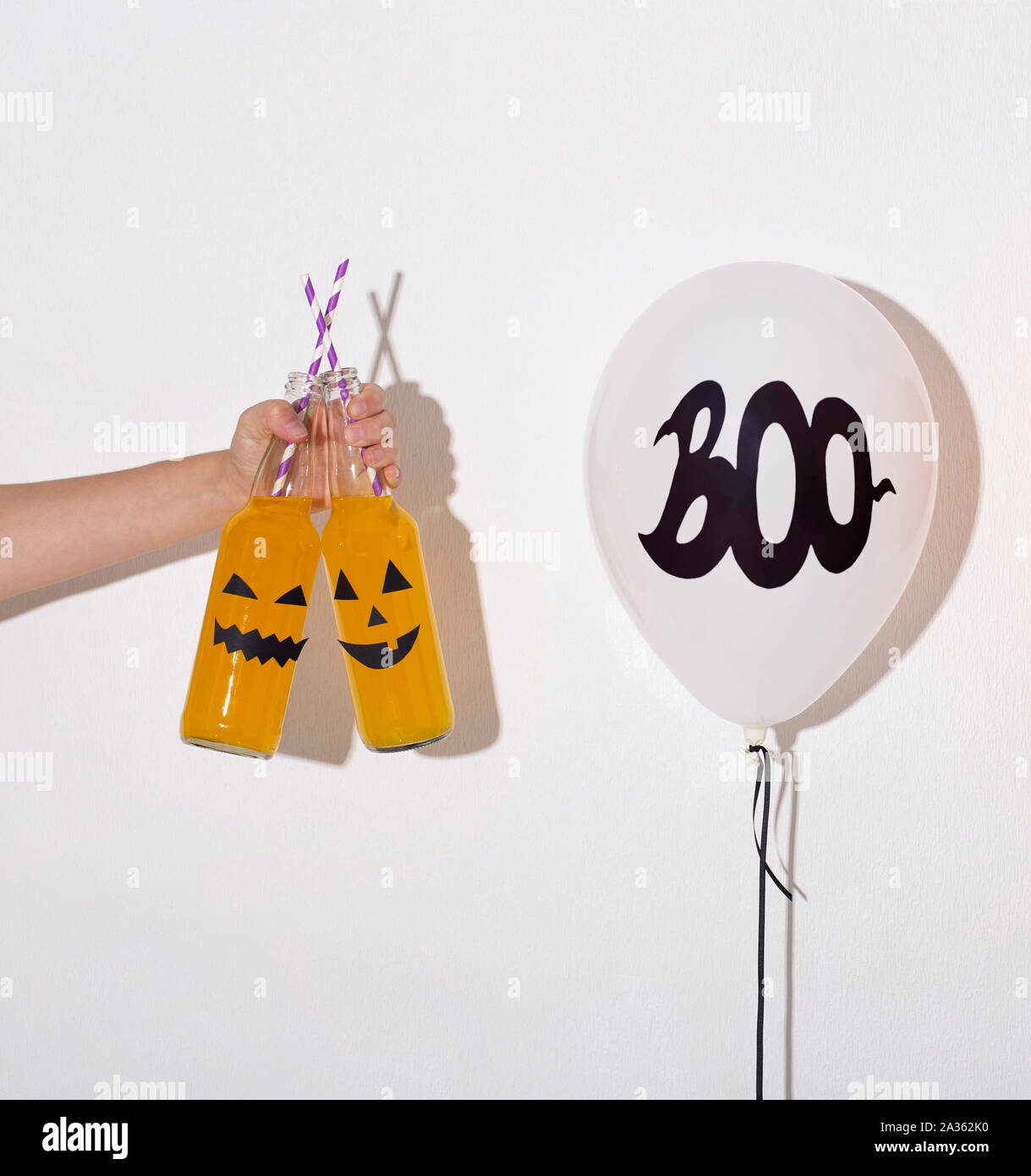 Frau mit gelben Halloween Cocktails in der Hand Stockfoto