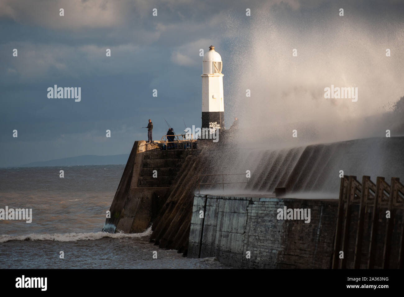 Porthcawl, County Borough von Bridgend, Wales, UK. 29. September 2019. Angler die brechenden Wellen bei Porthcawl Leuchtturm brave in South Wales. Stockfoto