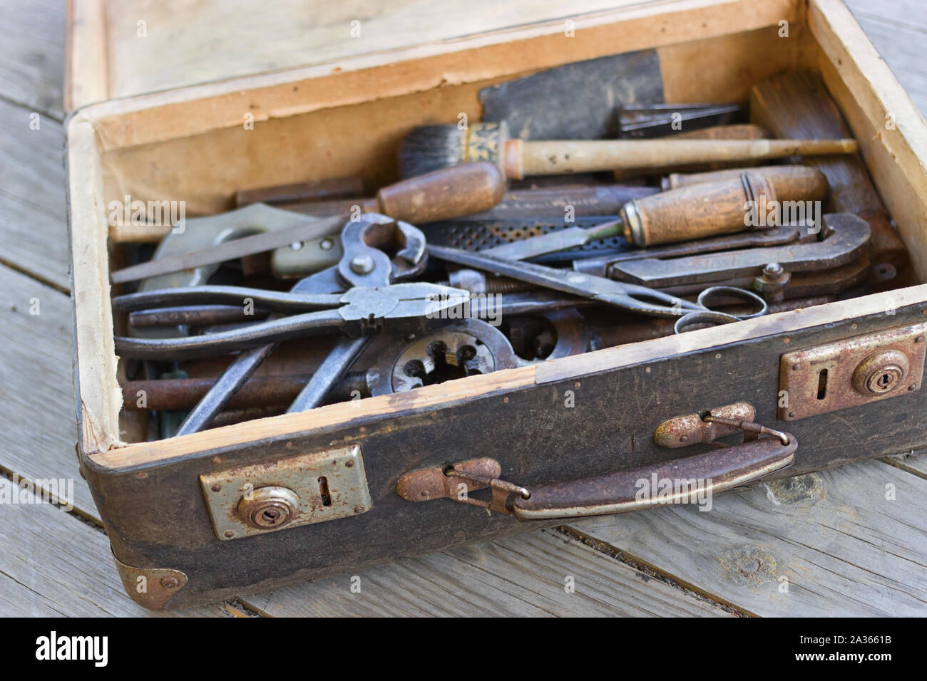 Einen Koffer mit alten Hand Tools auf einem Holz- Hintergrund. Fokus auf den Koffer. Stockfoto