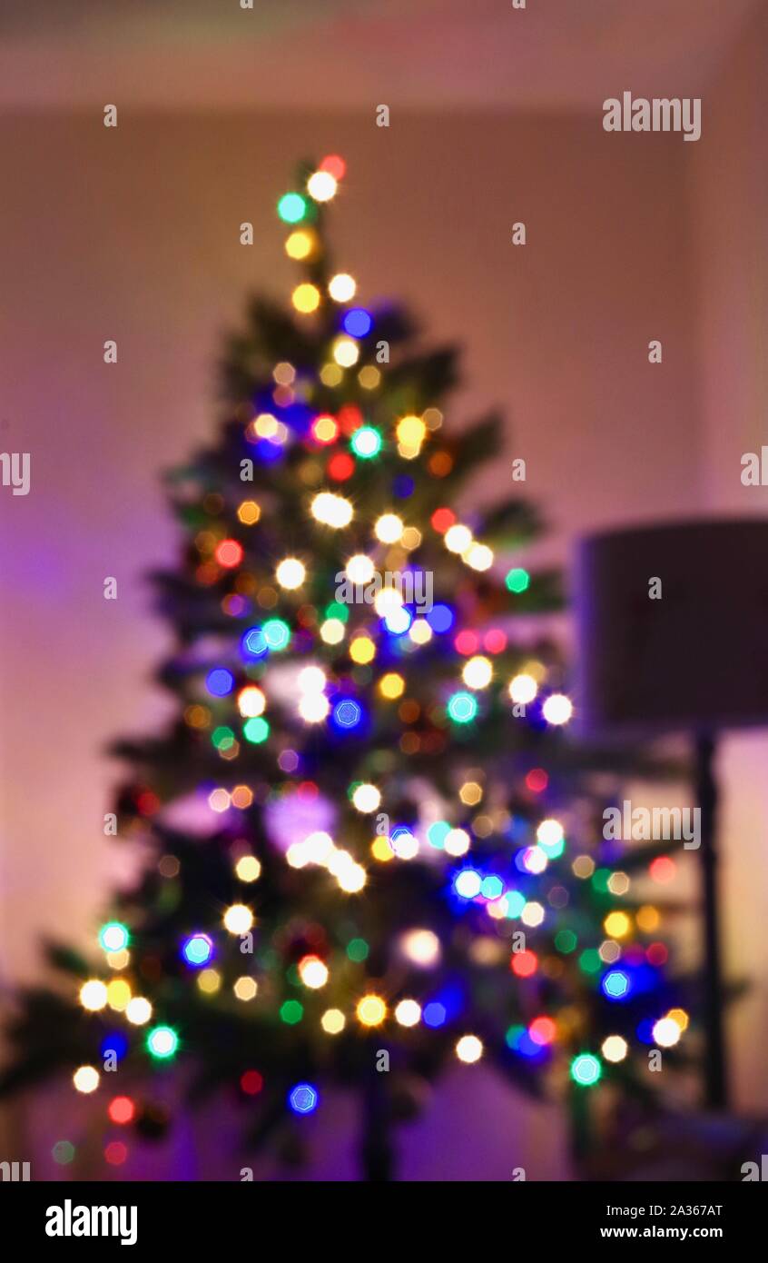 Weihnachtsbaum Glühende mit Lichterketten in einem Wohnzimmer. Devon, UK. Stockfoto
