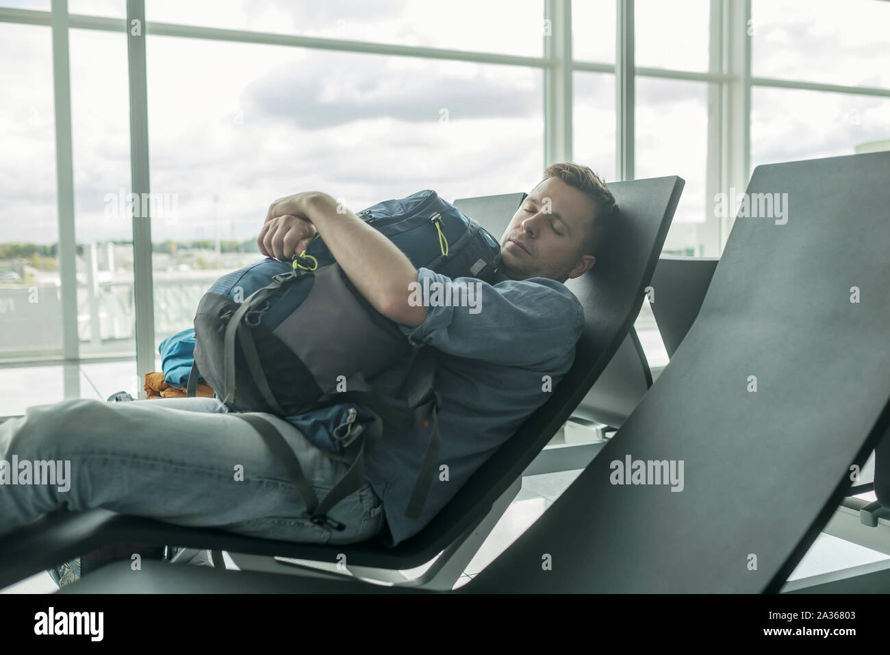Reifer Mann im Flughafen schlafen im Terminal Stockfoto