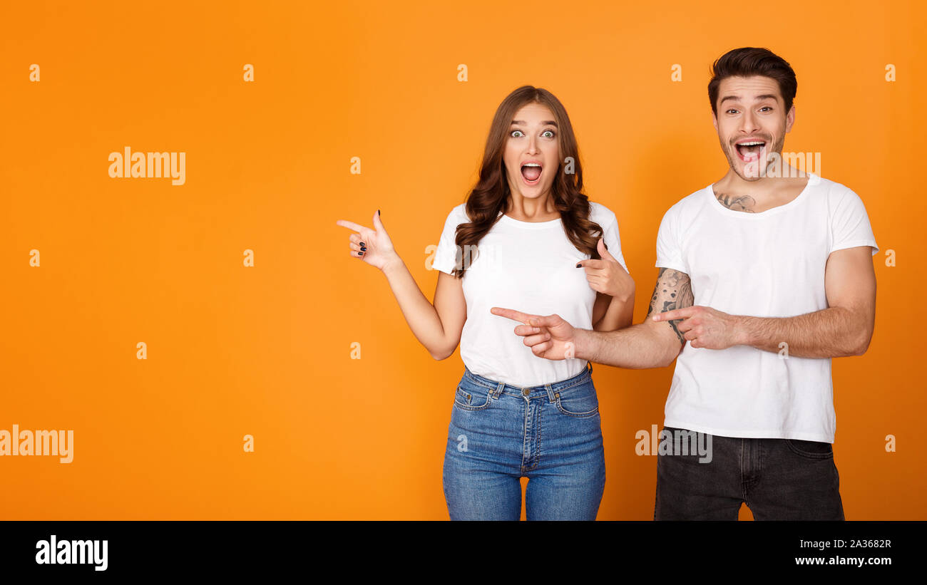 Mann und Frau Pointing Finger auf freien Speicherplatz Schockiert Stockfoto