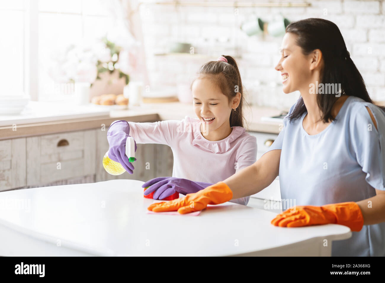 Fröhliche Mutter und Tochter Reinigung Küche zusammen Stockfoto