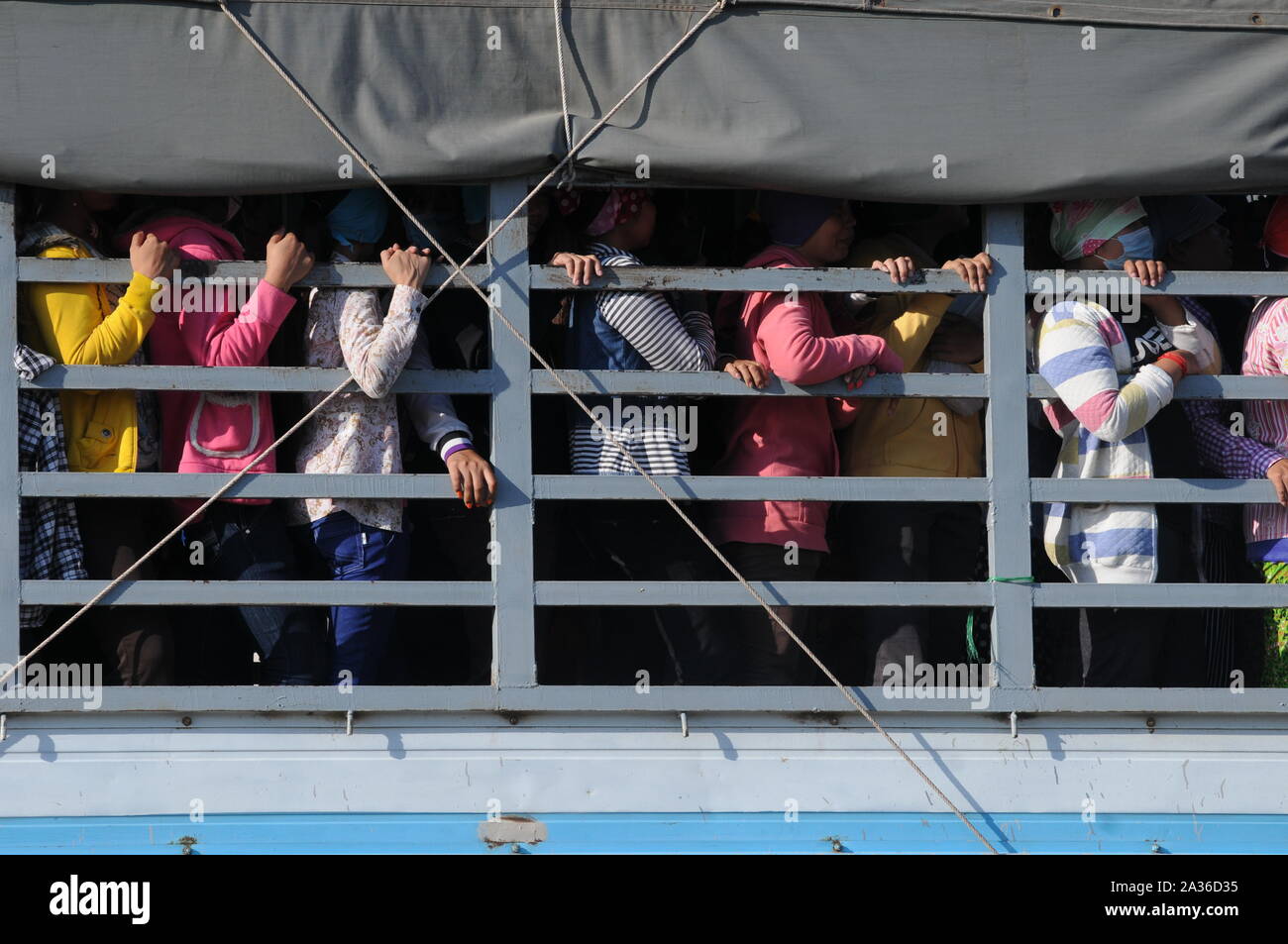 Textilarbeiterinnen überfüllt an der Rückseite eines Lkw, Pendeln nach Hause nach Arbeit, Phnom Penh, Kambodscha. © kraig Lieb Stockfoto