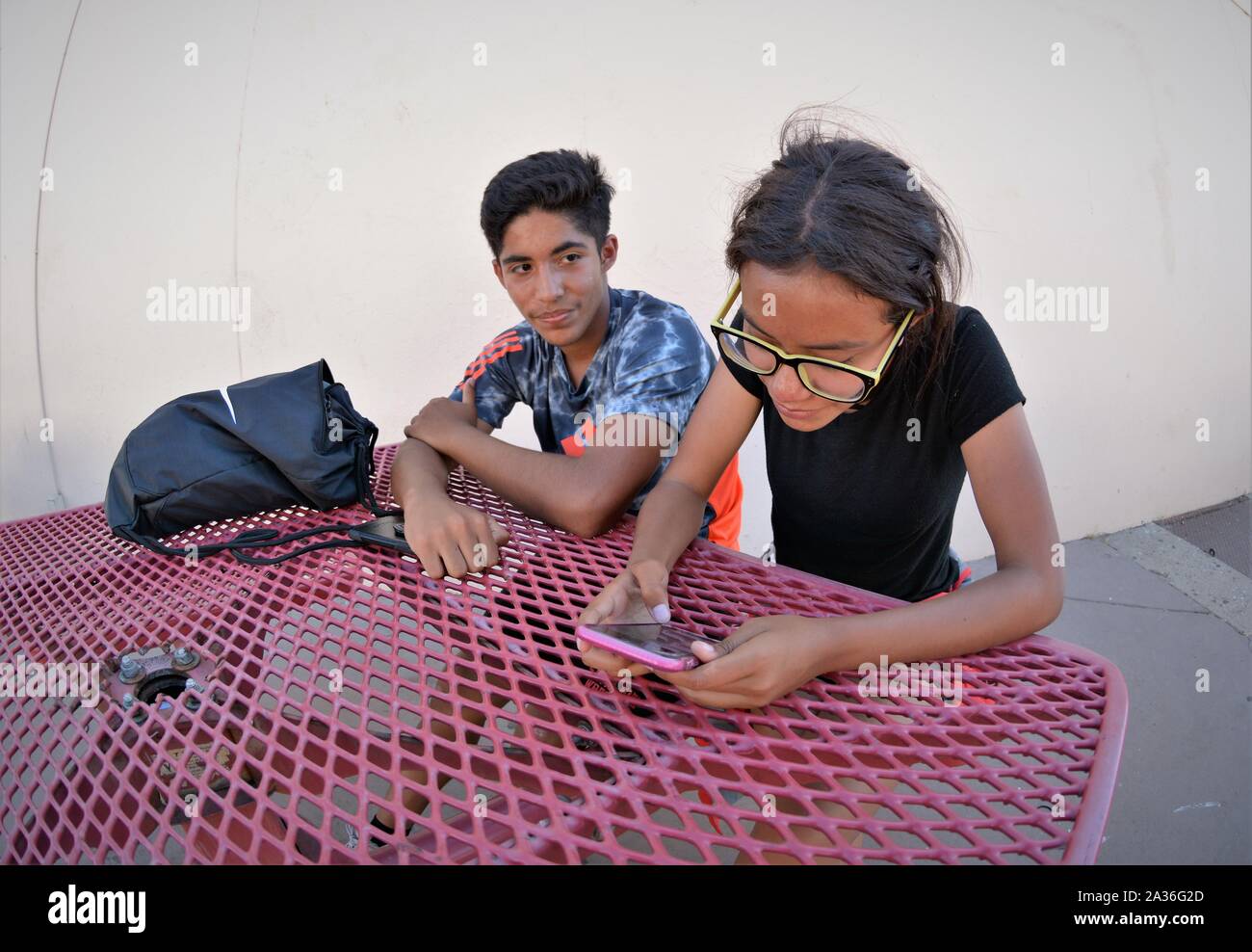 Junge und Mädchen Familie Hispanic mexikanischen Latin Mitglieder in der High School in Kalifornien spielen, arbeiten mit Handy Stockfoto