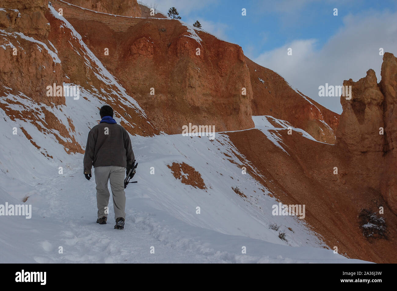 Winter Szene des jungen Mannes Wandern auf verschneiten Trail im roten Felsen Berg in Bryce Canyon Stockfoto