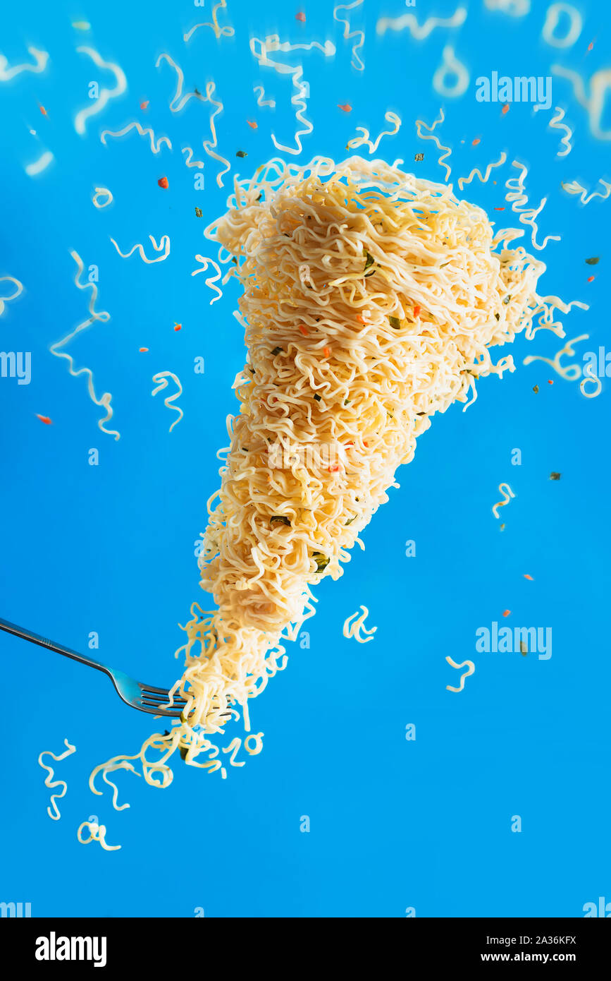 Nudel Tornado mit einer Gabel, instant Ramen in Aktion. Inspiration Konzept mit kreativen Essen Fotografie und Bewegung. Stockfoto