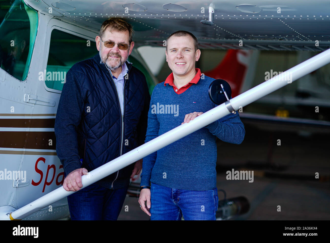30. September 2019, Rheinland-Pfalz, Bad Dürkheim: Die Piloten Otto-Wilhelm (l) und Marc Umstätter stehen auf dem Flugplatz bei einem Cessna 182 in einem Hagel plane (dpa ''Wackeln tuts immer': Besuchen Sie das schlechte Wetter Piloten der Pfalz") umgewandelt. Foto: Uwe Anspach/dpa Stockfoto