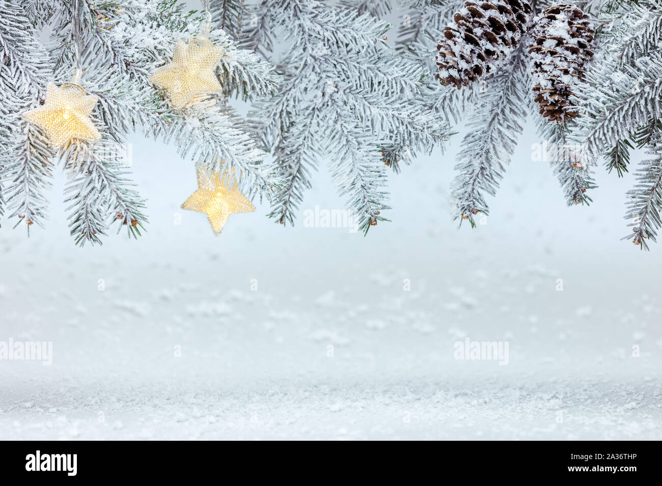 Tannenbaum Äste mit Kegel unter Schnee mit Stern leuchtet Girlande. Neues Jahr Hintergrund Stockfoto