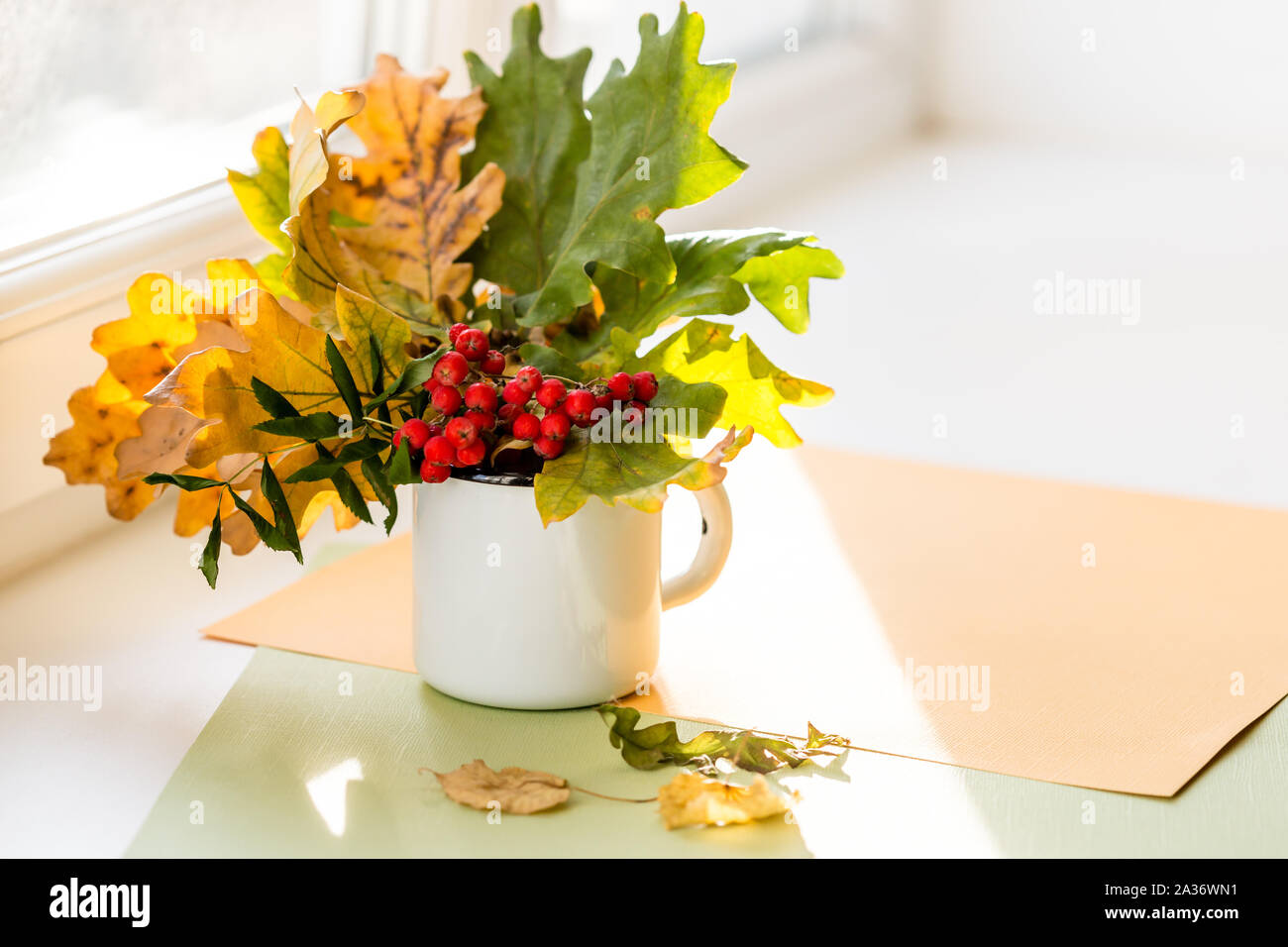 Herbst Komposition mit Strauß gelber Blätter und Zweige Mountain Ash in die Tasse. Herbst Jahreszeit Konzept, kopieren Raum Stockfoto