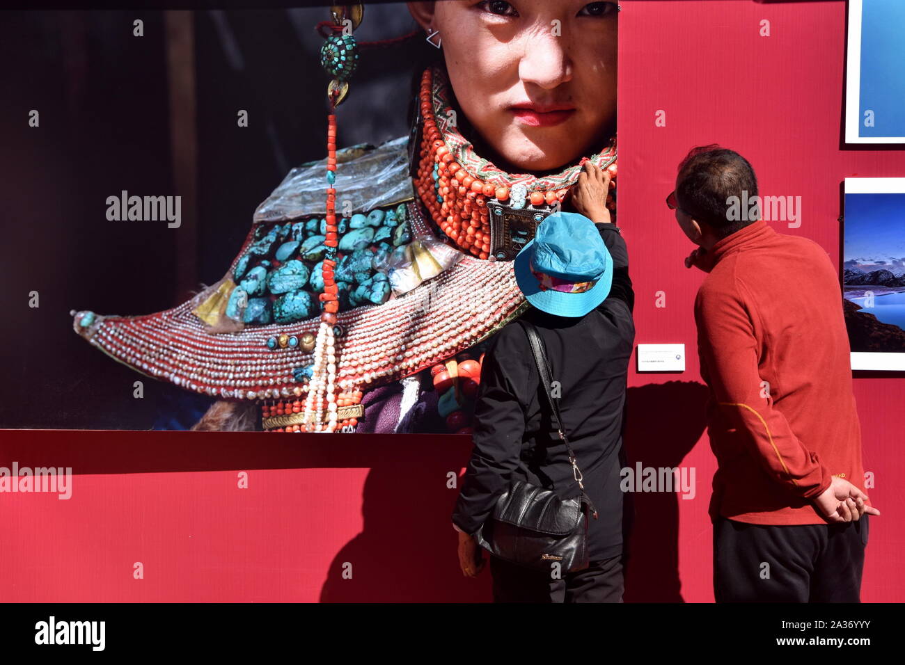 Lhasa, China's Tibet autonomen Region. 4. Okt, 2019. Besucher sehen eine fotografische Arbeit während der 12 Qomolangma Tibet Fotoausstellung angezeigt auf dem Platz der Potala Palast in Lhasa, der Hauptstadt von Südwesten Chinas Tibet autonomen Region, 4. Oktober 2019 statt. Über 400 fotografische Werke, darunter 100 historische Bilder, die ein breites Spektrum der tibetischen Themen wie Folk-custom, Kultur und Geographie auf Anzeige während der Ausstellung waren. Credit: Zhou Jinshuai/Xinhua/Alamy leben Nachrichten Stockfoto