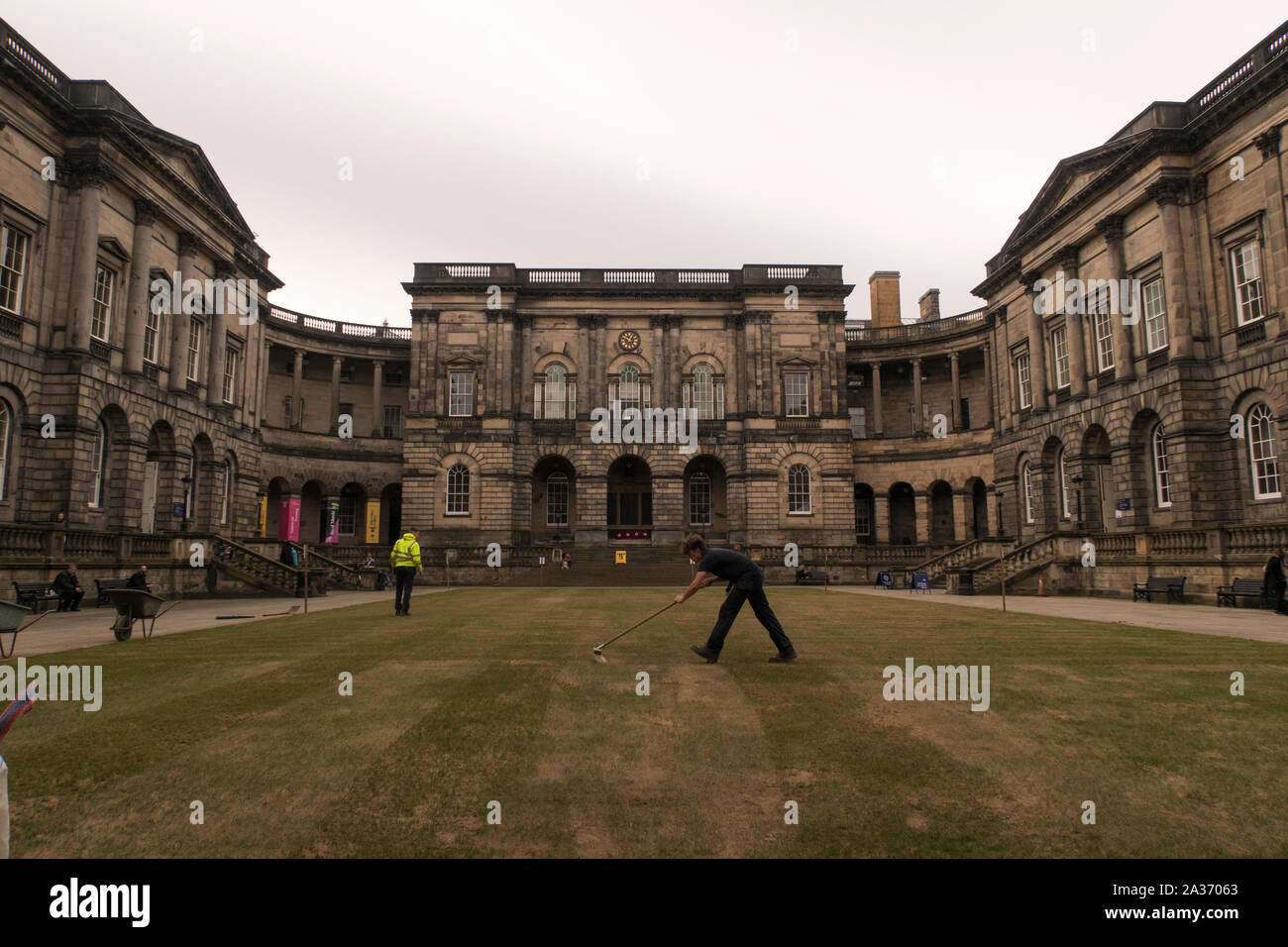 Ein Mann fegt das Gras an der Universität Edinburgh Viereck Stockfoto