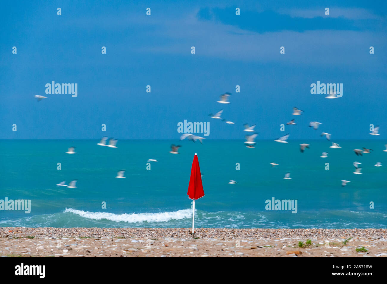 Mit der Ankunft der Herbst, der Einzige, der sich zu erinnern, die nun beendete Saison ist eine rote Sonnenschirm Stockfoto