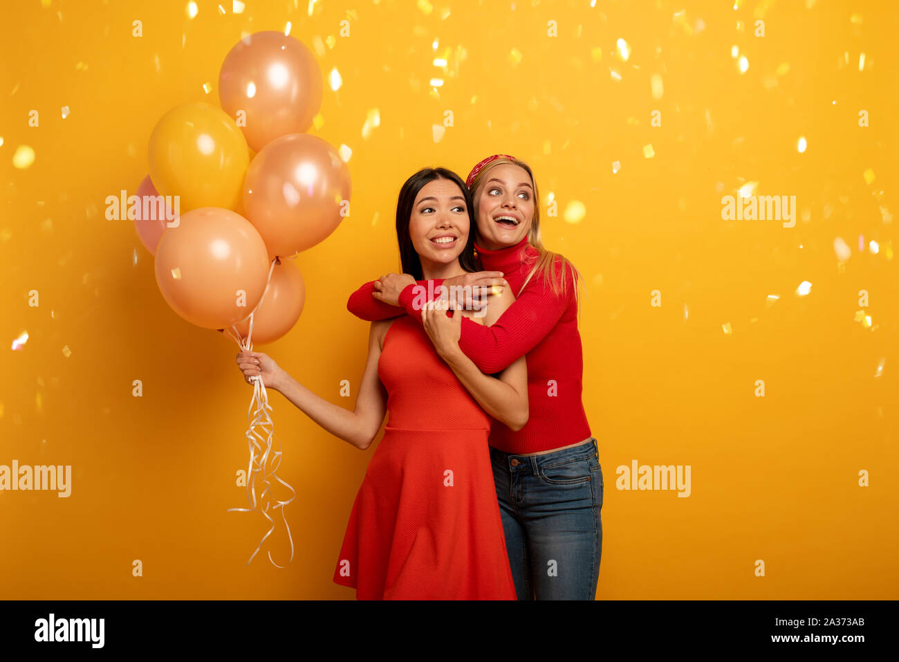 Mädchen bereit für eine Party mit Luftballons. Freudige ein Glück Ausdruck. Gelber Hintergrund Stockfoto