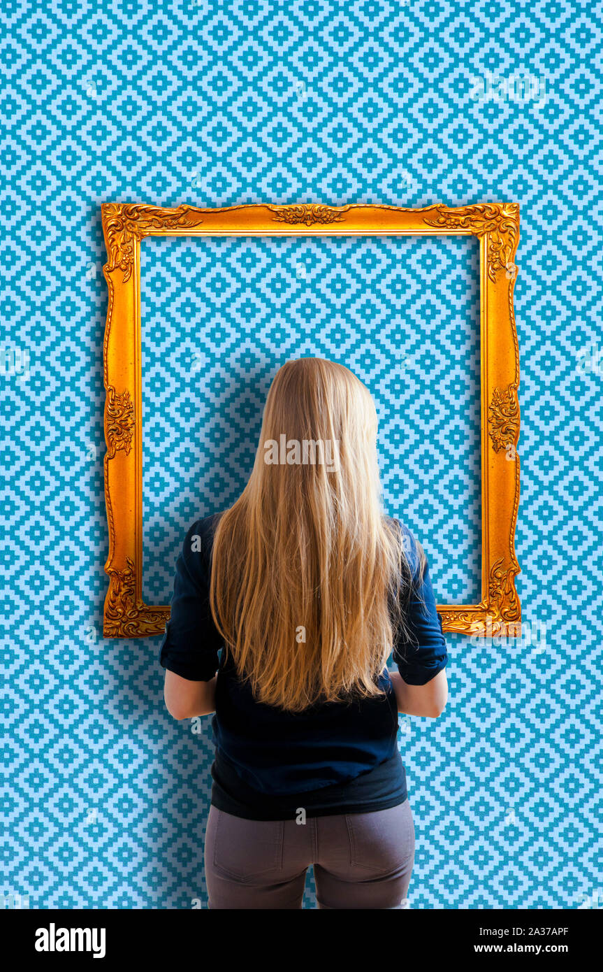 Blonde Mädchen vor einem leeren goldenen Bilderrahmen Stockfoto