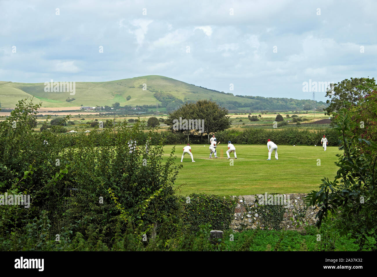 Männer spielen Kricket Spiel auf Feld in das Dorf in der Nähe von Rodmell Lewes in East Sussex England UK KATHY DEWITT Stockfoto