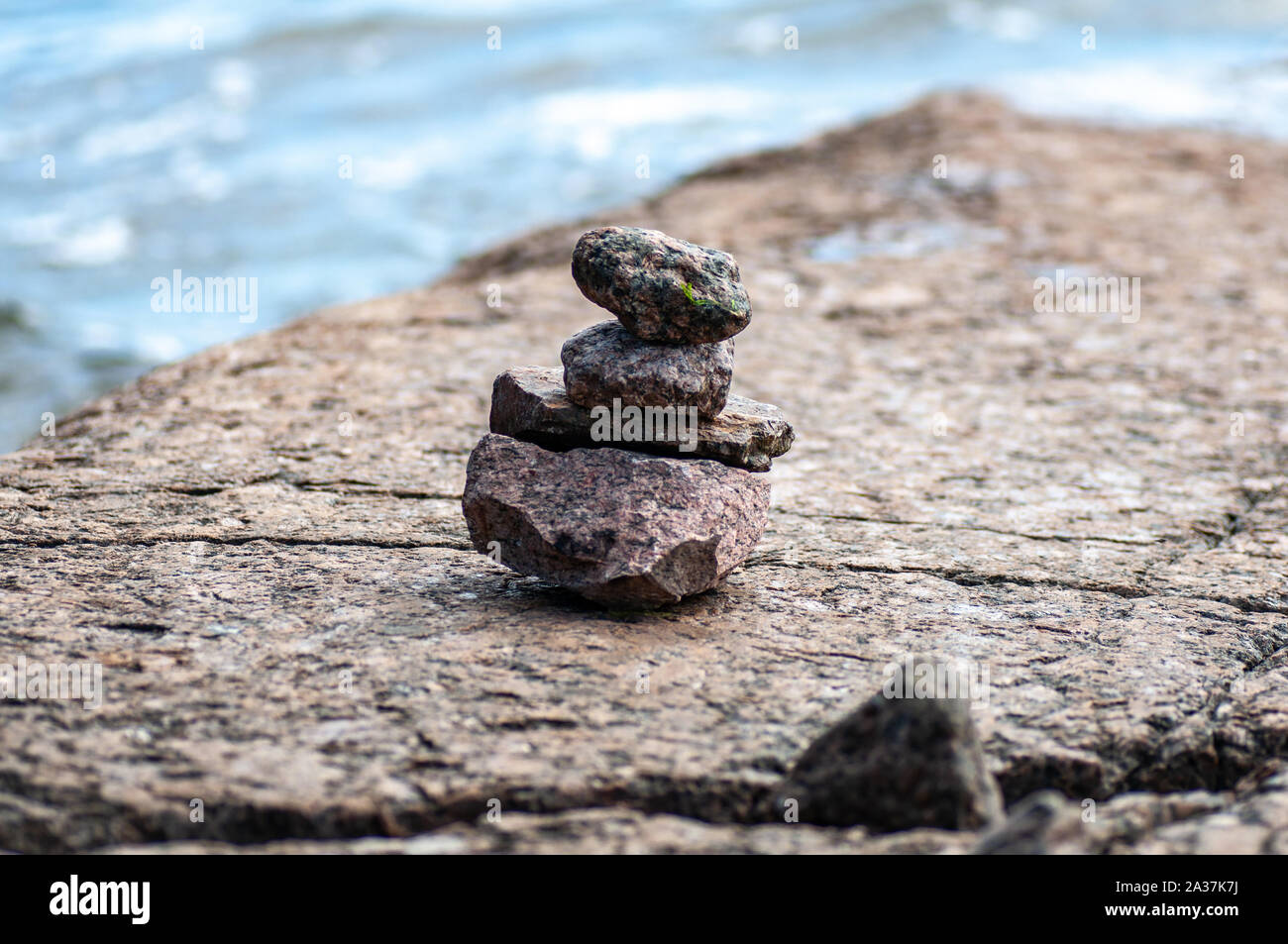 Die Steine der Pyramide auf Sand symbolisiert zen, Harmonie, Balance. Meer im Hintergrund. Stockfoto