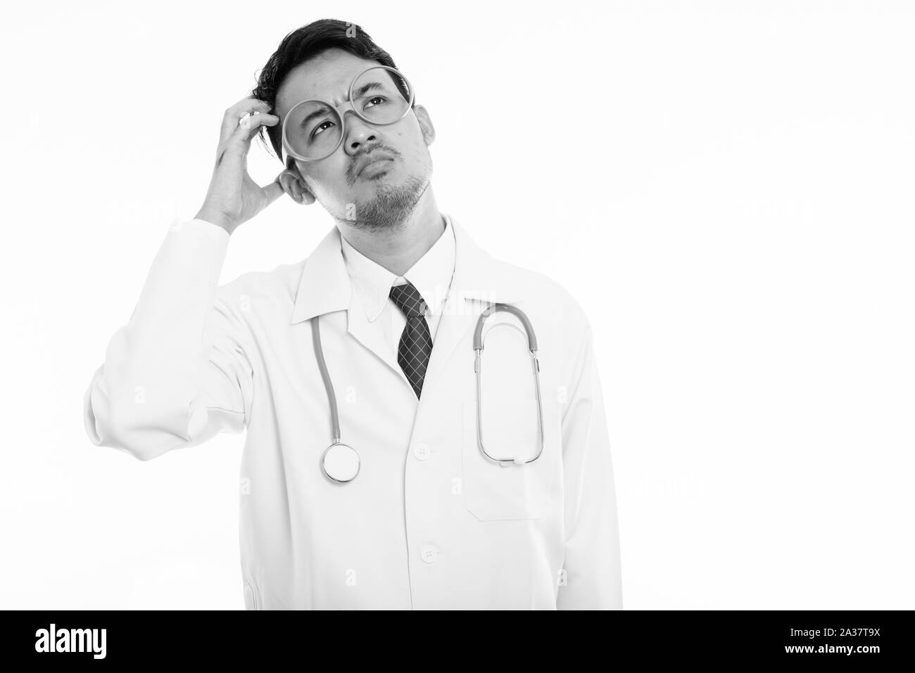 Studio shot junger asiatischer Mann Arzt denken beim Kratzen Kopf Stockfoto