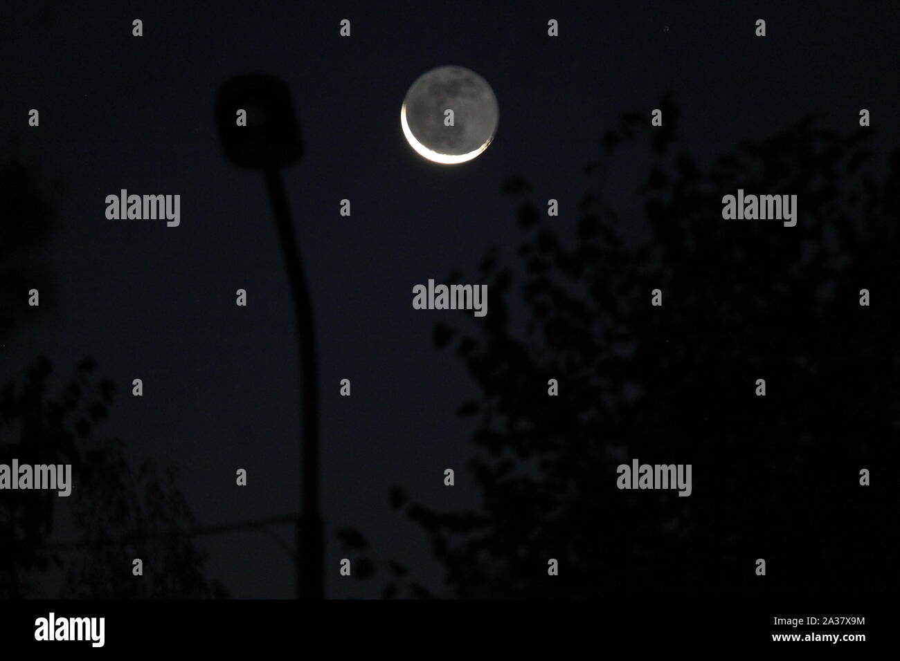 Festplatte mit abnehmender Mond leuchten im Dunklen herbst himmel Stockfoto