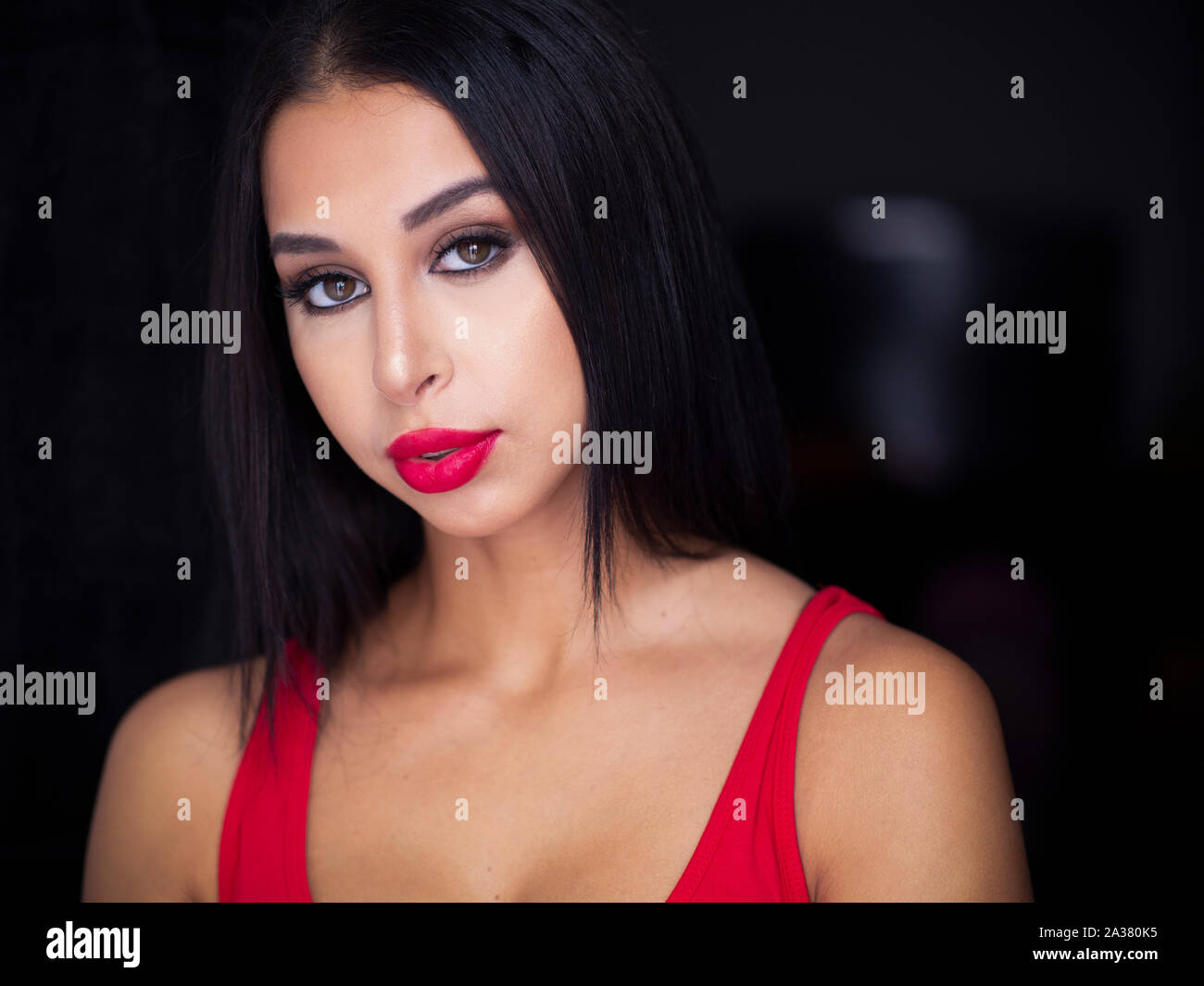 Schöne junge Frau das Tragen der roten Kleidung und roten Lippenstift Stockfoto