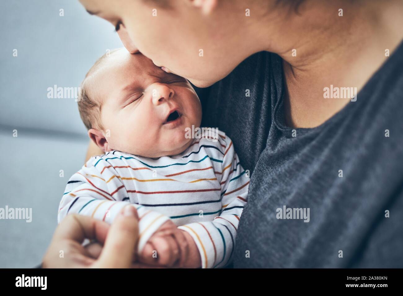 Mutter mit Kind. Frau küsste ihre 4 Tage alten Sohn zu Hause. Stockfoto