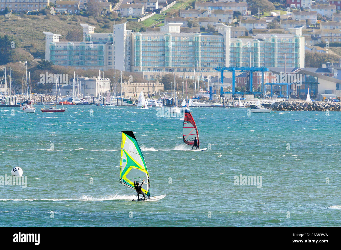 Wyke Regis, Dorset, Großbritannien. 6. Oktober 2019. UK Wetter. Windig und Sonnenschein sorgen für perfekte Bedingungen für Wassersport wie Segler, Windsurfer und Kitesurfer zum Wasser in Portland wellenbrecher an Wyke Regis in der Nähe von Weymouth in Dorset, wie Sie die Geschwindigkeit über das Meer. Foto: Graham Jagd-/Alamy leben Nachrichten Stockfoto