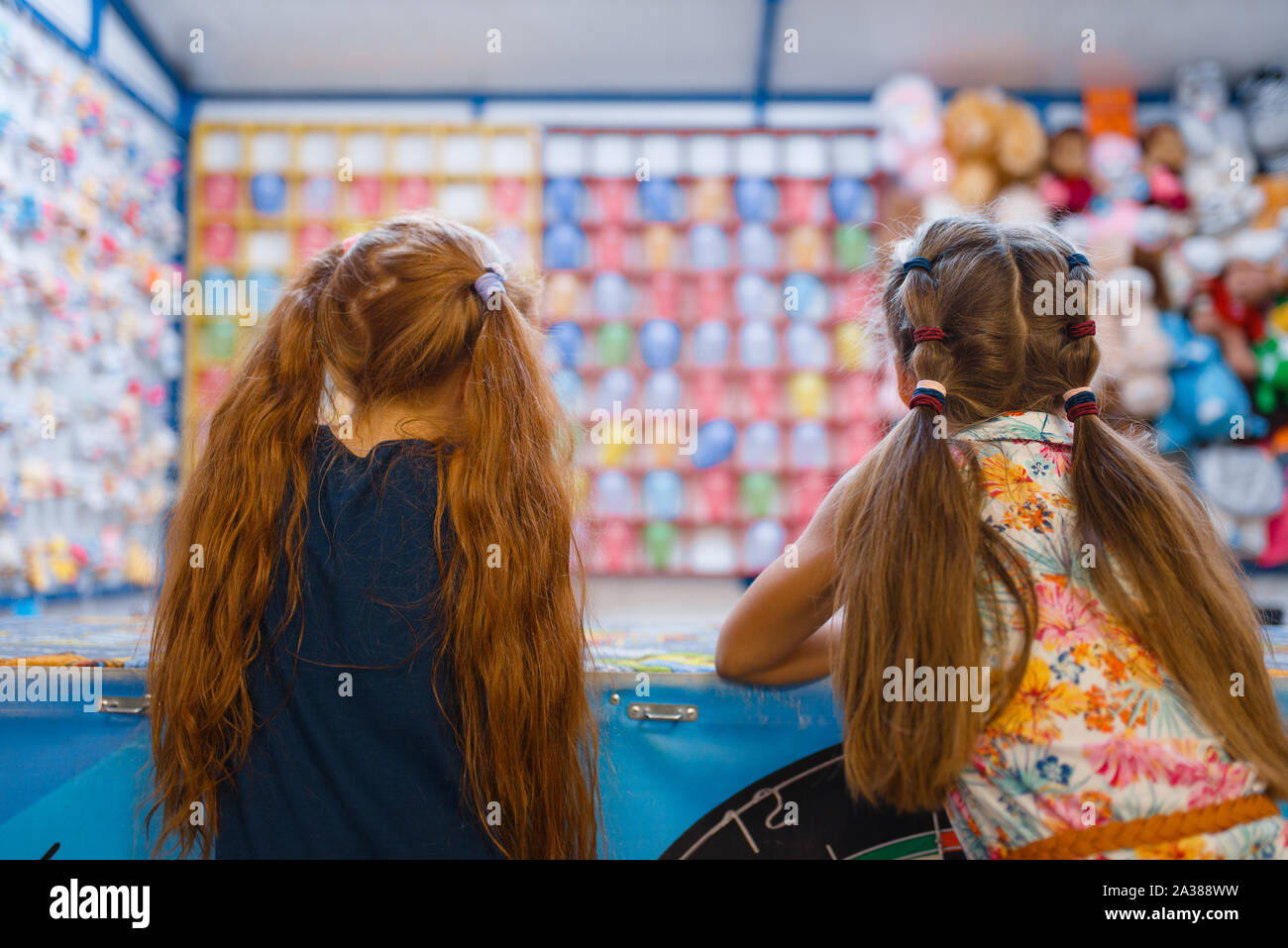 Zwei kleine Freundinnen spielen in Shooting Gallery Stockfoto