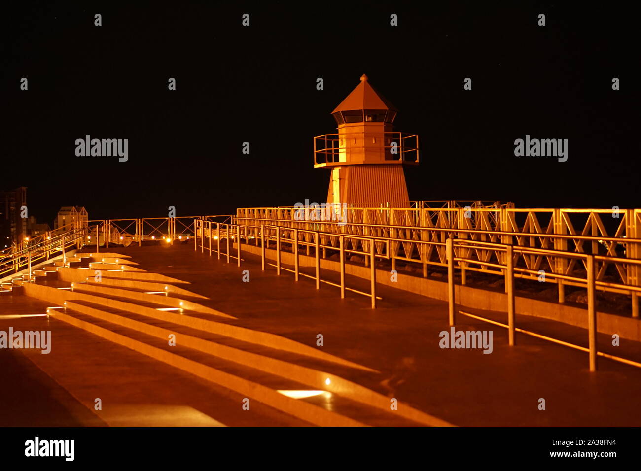 Eine gelbe Leuchtturm Watch Tower Struktur abends beleuchtet Stockfoto