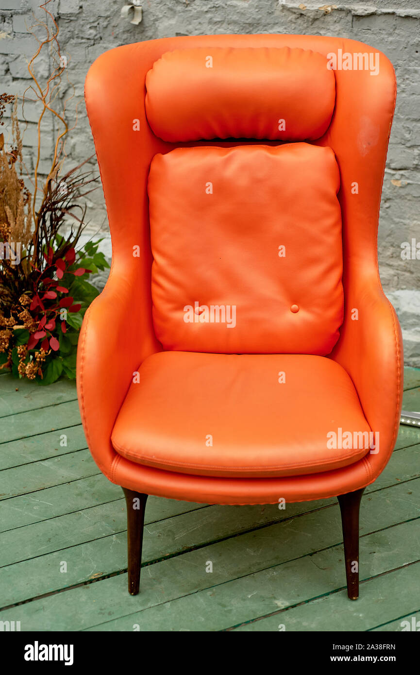 Orangefarbener Kunstlederstuhl auf der Terrasse im Loft-Stil Stockfoto