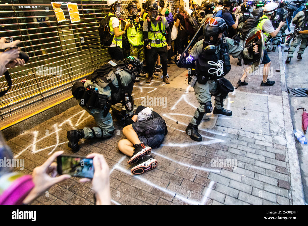 Die Bereitschaftspolizei pin eine Demonstrantin zu Boden während der Demonstration. Eingabe der 18 Wochenende der Unruhen, Demonstranten marschierten im Regen nach einer Anti-mask Gesetz wurde in einer Bemühung, Demonstrationen abzuhalten. Die Demonstranten skandierten Parolen und fuhr fort zu Fragen für die fünf Forderungen erfüllt werden. Die Demonstranten zu Zusammenstößen zwischen Polizei und wurden mit Gas, Gummigeschossen getroffen, und einer Wasserkanone bis mehrere wurden schließlich verhaftet. Stockfoto