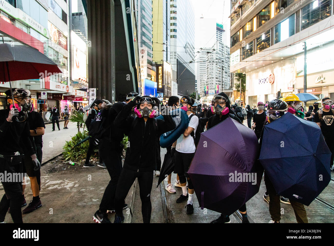 Eine Demonstrantin sieht die Polizei die Bewegung während der Demonstration. Eingabe der 18 Wochenende der Unruhen, Demonstranten marschierten im Regen nach einer Anti-mask Gesetz in einer Bemühung, Demonstrationen abzuhalten übergeben wurde. Die Demonstranten skandierten Parolen und fuhr fort zu Fragen für die fünf Forderungen erfüllt werden. Die Demonstranten zu Zusammenstößen zwischen Polizei und wurden mit Gas, Gummigeschossen getroffen, und einer Wasserkanone bis mehrere wurden schließlich verhaftet. Stockfoto