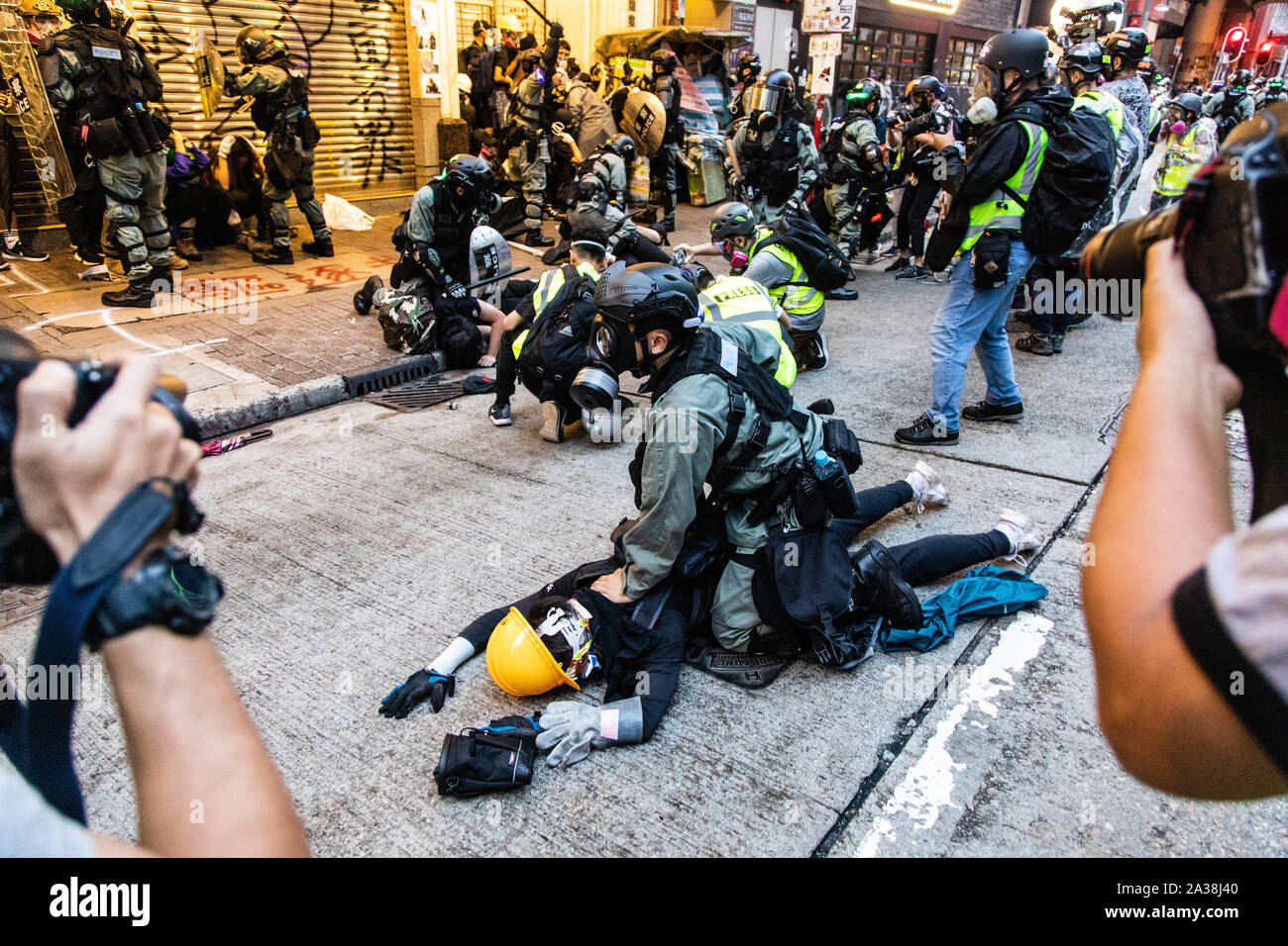 Die Bereitschaftspolizei pin eine Demonstrantin zu Boden während der Demonstration. Eingabe der 18 Wochenende der Unruhen, Demonstranten marschierten im Regen nach einer Anti-mask Gesetz wurde in einer Bemühung, Demonstrationen abzuhalten. Die Demonstranten skandierten Parolen und fuhr fort zu Fragen für die fünf Forderungen erfüllt werden. Die Demonstranten zu Zusammenstößen zwischen Polizei und wurden mit Gas, Gummigeschossen getroffen, und einer Wasserkanone bis mehrere wurden schließlich verhaftet. Stockfoto