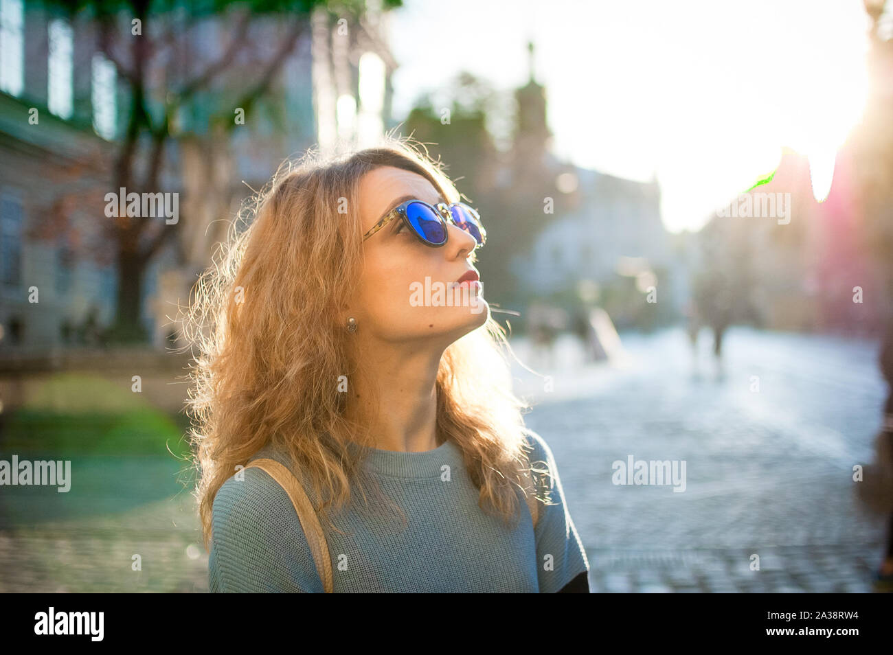 Seitenansicht der jungen Frau in Blau Sonnenbrille in den frühen Morgenstunden im alten Europäischen Stadt auf leeres Quadrat Stockfoto