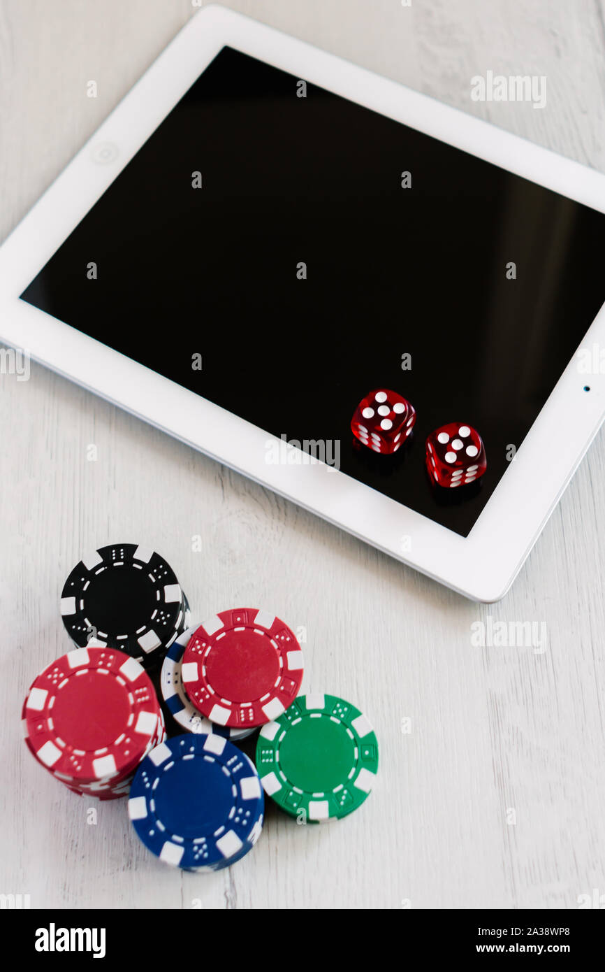 Poker chips und roten Würfel auf einem Tablett. Wetten online App Konzept. Das Spielen auf der Website und Geld gewinnen. Stockfoto