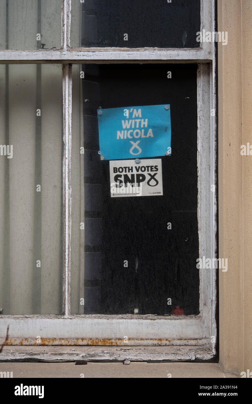 "Ich bin mit Aufklebern Nicola' und 'Beide Stimmen SNP' auf einem Grubby, Fenster, ein Überbleibsel aus vergangenen schottischen Parlamentswahlen. Stockfoto