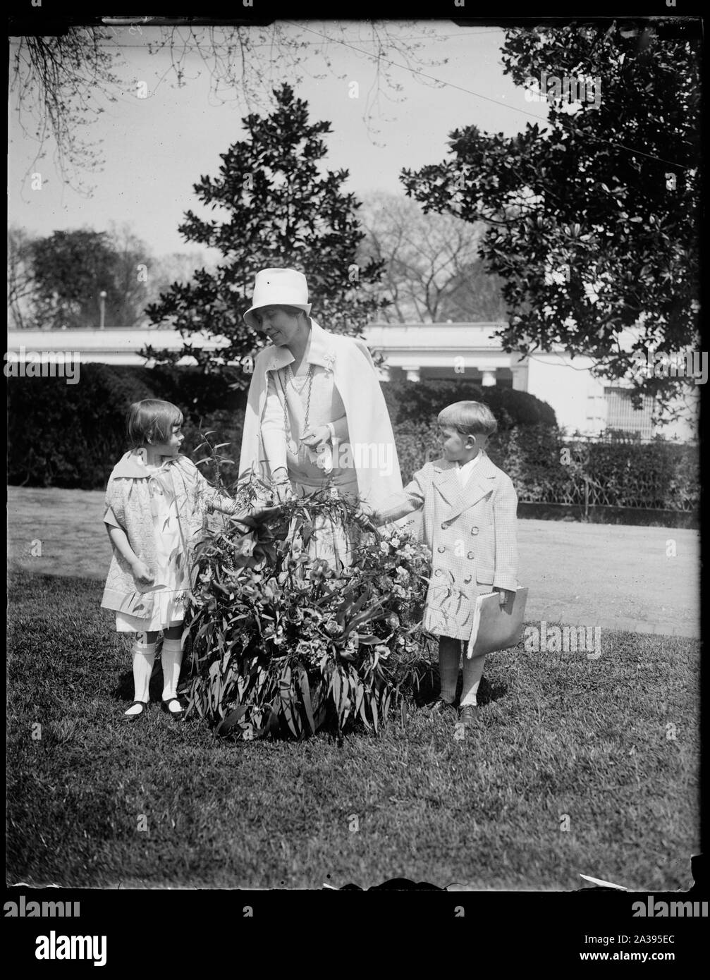 Heilsarmee Kinder von Kalifornien senden Frau Coolidge ein Geschenk der Blumen mit dem Flugzeug. Einen schönen Korb mit Blumen mit dem Flugzeug geschickt durch die Kinder der Heilsarmee zu Hause Lytton Springs, Kalifornien, wurde von Frau Coolidge im Weißen Haus heute vorgestellt hat. Ketha Holtz, Tochter von Staff-Captain Ernest R. Holtz, Potomac Divisional Commander der Heilsarmee in Washington und Robert Rose, Sohn von Fähnrich Robert Rose der Heilsarmee, gezeigt werden, dass die Präsentation, die auch eine Nachricht lesen: Sehr geehrte Frau Coolidge: Wir schicken Sie diese Blumen, weil wir sie lieben, im Lieferumfang enthalten Stockfoto