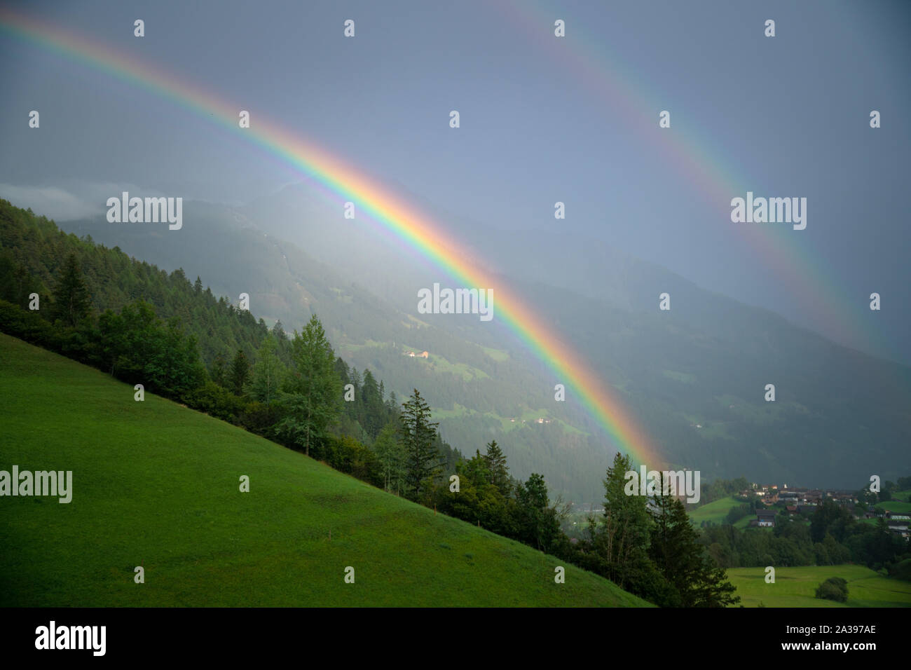 Doppelter Regenbogen über üppige Alpenlandschaft, Lienz, Österreich Stockfoto