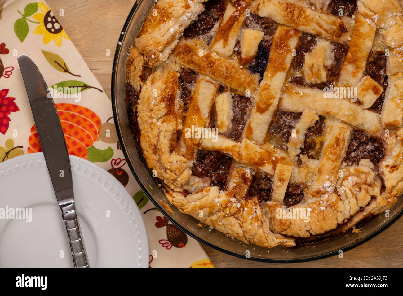 Rustikale hausgemachte Obst Torte im Glas Teller auf einen Holztisch mit themed Servietten, Ansicht von oben. Stockfoto