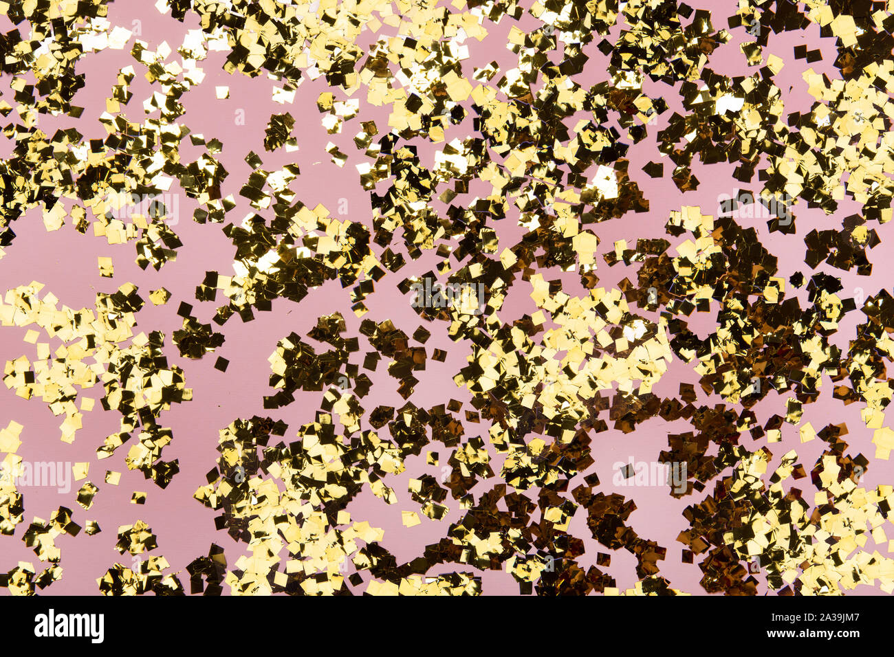 Golden Konfetti Glitzer auf rosa Hintergrund. Festliche pastell Kulisse. Greeteng Karten Vorlage. Stockfoto