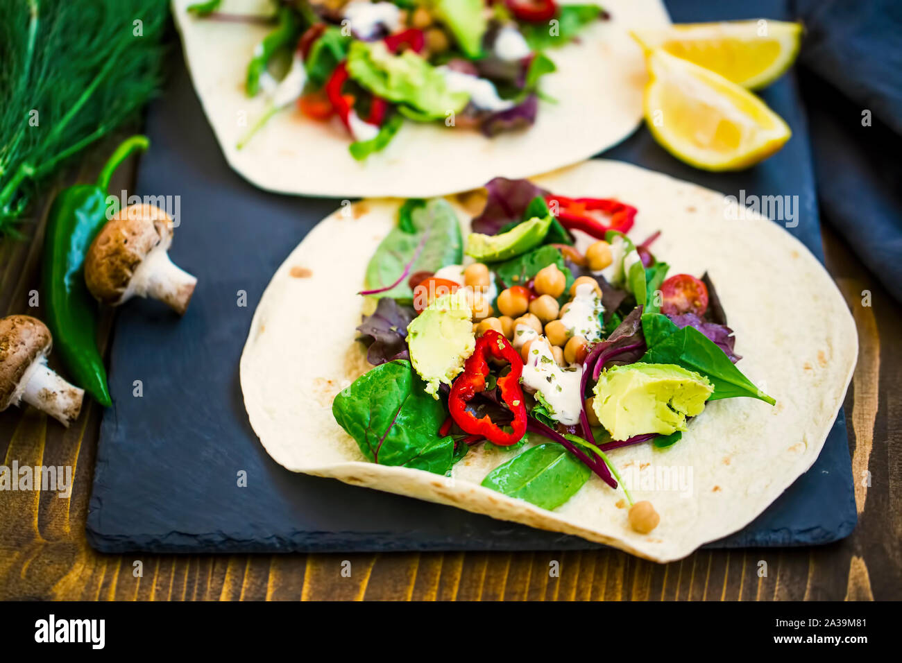 Vegan Wraps mit Salat, Kichererbsen, Gemüse und Avocado, gesunde Tortilla mit Gemüse gefüllt, vegetarisches Gericht Stockfoto