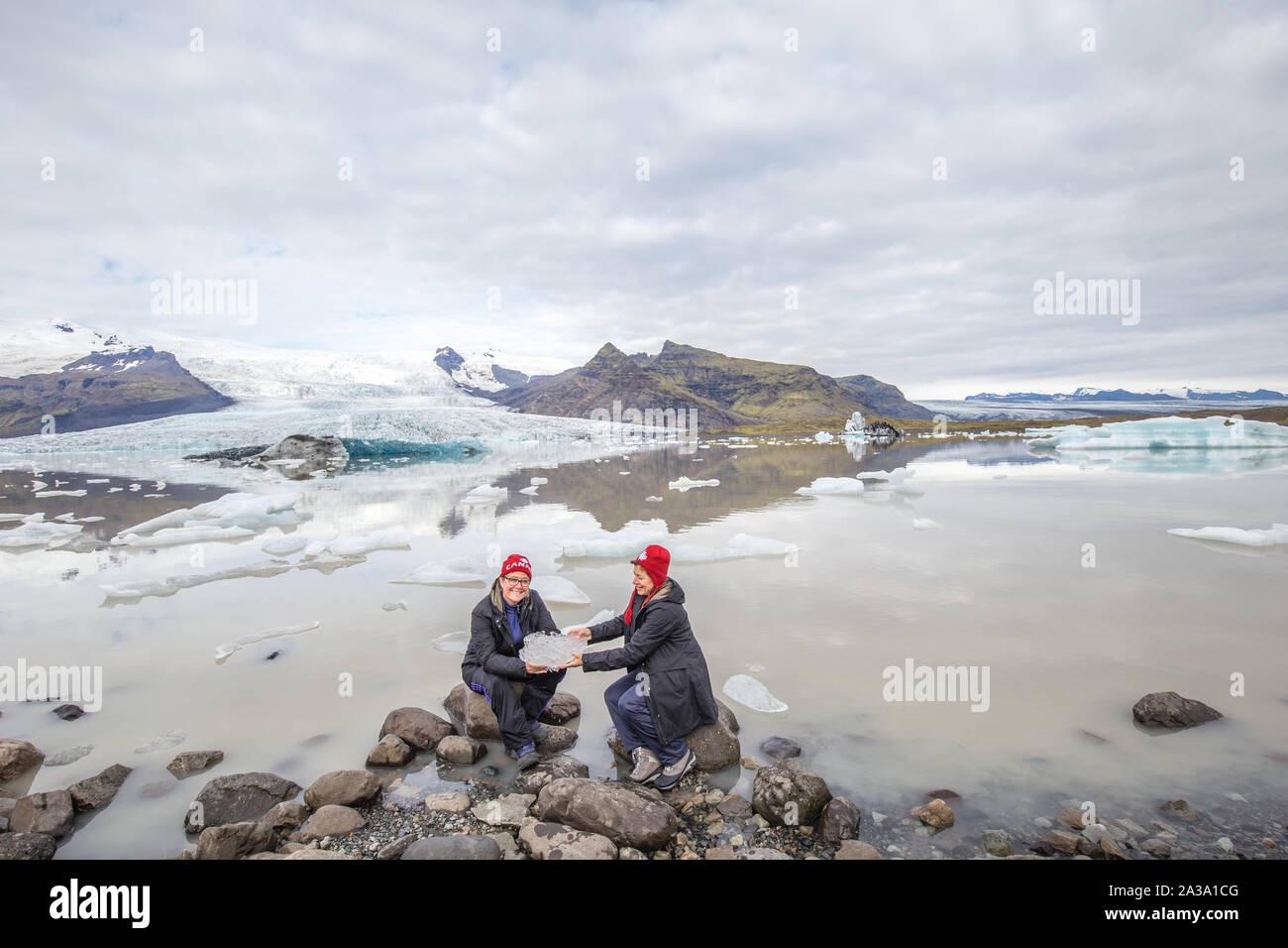 Frauen, die ein kleiner Eisberg in der Nähe der Gletscher Lagune in Island Stockfoto