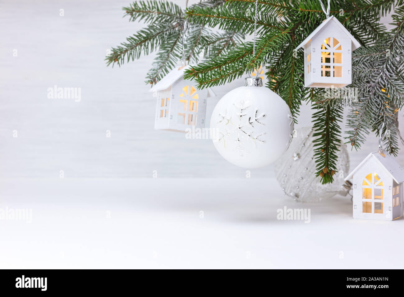 Christmas tree branch, Holz- dekorative Spielzeug Häuser Garland und Kugeln aus Glas. neues Jahr Urlaub Hintergrund Stockfoto